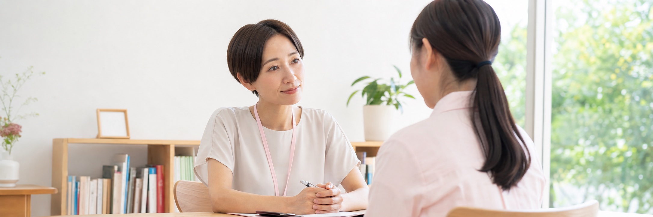 相談者の話を丁寧に聴く女性相談員と安心できる相談室のイメージ